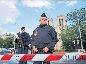  ?? AP PHOTO ?? Police officers seal off the access to Notre Dame cathedral, seen in the background, after a man attacked officers with a hammer outside the famous landmark, in Paris, France, Tuesday.