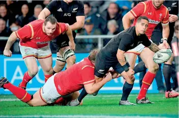  ??  ?? New Zealand's Aaron Smith (R) gets a pass away as he is tackled by Tomas Francis of Wales (bottom L) during the third rugby Test against Wales at Forsyth Barr Stadium in Dunedin - AFP