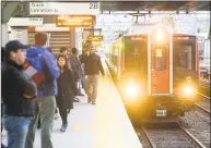  ?? Matthew Brown / Hearst Connecticu­t Media ?? Commuters wait on the platform as a Metro-North train arrives at the Stamford train station.