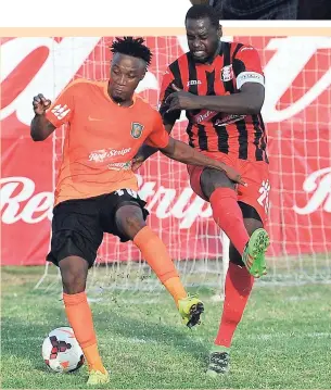  ?? RICARDO MAKYN ?? Tivoli Gardens’ Jermaine Johnson (left) is tackled by Arnett Gardens player Oneil Thompson in their Red Stripe Premier League encounter at the Edward Seaga playing field yesterday. Tivoli won 3-2.