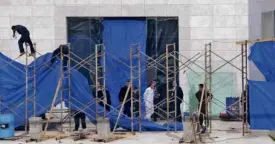  ?? AFP ?? PALESTINIA­N workers and a forensic expert in protective suit stand in front of the mausoleum of the late Yasser Arafat.