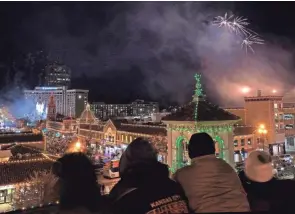  ?? CHARLIE RIEDEL/AP ?? People watch from a parking garage as the Christmas lights at the