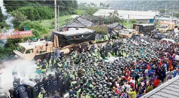  ??  ?? Stand back: Riot police blocking residents and protesters as US THAAD system equipment pass near a former golf course in the southern county of Seongju. — AFP