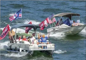  ?? THE ASSOCIATED PRESS ?? A Trump masked boat rider waving to those on the Hwy 421 bridge on Sept. 5, during the South Holston Trump Boat Parade in Bristol, Tenn.