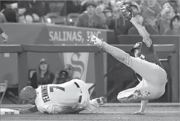  ?? Wally Skalij Los Angeles Times ?? ATHLETICS PITCHER Kendall Graveman gets f lipped while tagging out the Angels’ Cliff Pennington at third base to complete an unassisted double play. Graveman also tagged out Ben Revere.