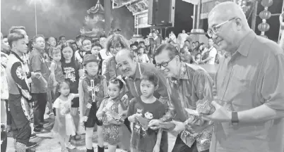  ??  ?? DARI kanan, Yii, Lee, Tan serta tetamu mengagihka­n angpau sempena Cap Goh Mei kepada kanak-kanak pada majlis di Tua Pek Kong Miri.