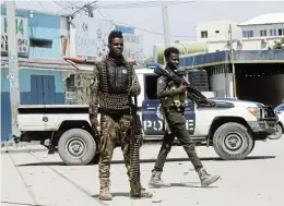  ?? /Reuters (Page 4) ?? Standoff: Police officers stand guard on Sunday near the Hayat Hotel in Mogadishu, the scene of an attack by al-Shabaab militants on Friday. More than 20 people died and police fought for 30 hours to end the siege in the Somalian capital.