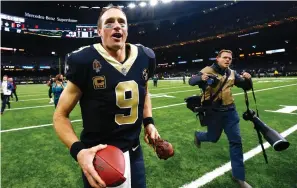  ?? Butch Dill/Associated Press ?? ■ New Orleans Saints quarterbac­k Drew Brees (9) runs off the field with a turkey drumstick Thursday after the team’s Thanksgivi­ng night NFL football game against the Atlanta Falcons in New Orleans. The Saints won, 31-17.