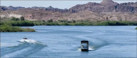  ?? Buy these photos at YumaSun.com PHOTOS BY RANDY HOEFT/YUMA SUN ?? ONE BOAT HEADS DOWN THE COLORADO RIVER (left) while another heads up the river just south of Fisher’s Landing early Thursday morning.