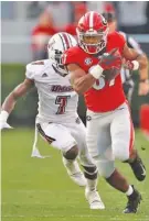  ?? AP PHOTO/JOHN BAZEMORE ?? Georgia wide receiver Tyler Simmons runs to the end zone for a touchdown catch during the first half of the Bulldogs’ 66-27 win against UMass on Saturday in Athens.