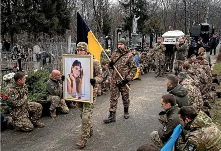  ?? AP ?? Ukrainian servicemen of Khartia battalion carry the coffin and a portrait of their comrade Vladyslava Chernyh, aka ‘‘Aida’’, a PhD student and combat medic, during her funeral in Kharkiv yesterday. Chernyh was killed during fighting between Russian and Ukrainian armed forces near Bakhmut.