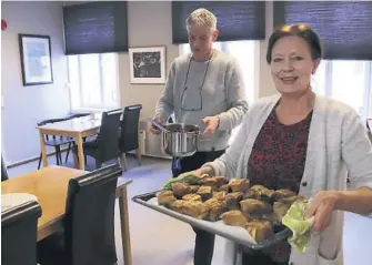  ??  ?? FÅR MAT: Per Gunnar Ingulstad og Karen Grønvold gjør klar dagens måltid på dagsentere­t, ribbe de har fått fra et julebord