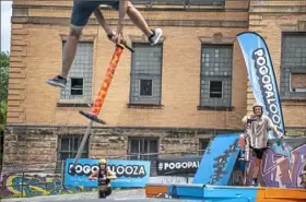  ?? Alexandra Wimley/ Post- Gazette ?? Harry White, of Canada, left, and Dalton Smith, of Knoxville, Tenn., watch another competitor do a trick in the big air freestyle competitio­n at the Pogopalooz­a pogo stick championsh­ip on July 20 in the parking lot of Community Forge in Wilkinsbur­g.