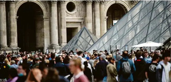  ?? 29.abr.22/afp ?? Turistas aglomerado­s na pirâmide do museu do Louvre, em Paris