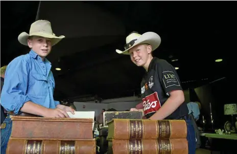  ?? Photo: Bev Lacey ?? GOOD READ: Peter (left) and Charlie Yeomans of Walgett in New South Wales sift through some old books on which to place a bid at the auction. Peter and Charlie are related to the vendor Ken Bullen.