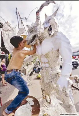  ?? ERNIE PEÑAREDOND­O ?? A teenager crafts an effigy of a dog-headed cartoon character in Barangay Longos, Malabon City yesterday. The effigy will be rigged to explode to welcome the Year of the Dog tonight, he said.