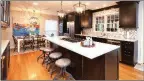 ??  ?? The stunning kitchen features quartz countertop­s, custom Brookhaven cabinetry and a large island with a breakfast bar.