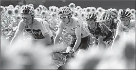  ?? AP/PETER DEJONG ?? Overall leader Geraint Thomas (second from left) and other riders pedal past a field of sunflowers during Thursday’s 18th stage of the Tour de France.