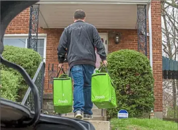  ?? Christian Snyder/Post-Gazette photos ?? Kevin McIntosh, of Connellsvi­lle, drops off groceries via Instacart from Costco in Homestead on Tuesday at the home of a woman who is immunocomp­romised.