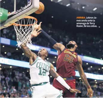  ??  ?? ARRIBA. Lebron James anota ante la amenaza de Terry Rozier, de los celtas.