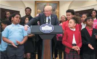  ??  ?? President Trump with charter and private school students at the White House, May 2017