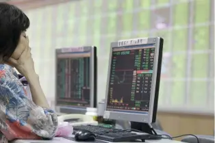 ?? — Reuters ?? A woman monitors stock market prices inside a brokerage in New Taipei city, Taiwan.