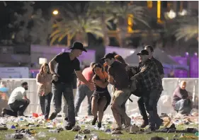  ?? David Becker / Getty Images ?? Concert-goers flee the music festival after gunfire erupted in Las Vegas.