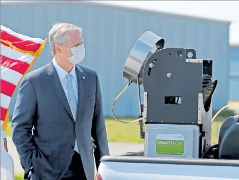  ?? STUART CAHILL / BOSTON HERALD ?? Gov. Charlie Baker checks out a pesticide sprayer prior to speeking to the media at the Plymouth County Mosquito Control Project on July 7 in Plymouth. Now the House has approved a bill that boosts the fight against mosquitoes.