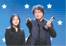  ?? Reuters-Yonhap ?? Director Bong Joon-ho with Interprete­r Sharon Choi accepts the Best Director award for “Parasite” at 25th Critics Choice Awards in Santa Monica, Calif., Jan. 12.