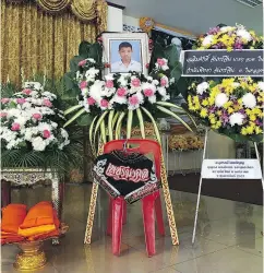  ?? ROMEO GACAD / AFP / GETTY IMAGES ?? A portrait of Muay Thai boxer Anucha Tasako, 13, and his boxing gear are placed next to his coffin during his funeral at a Buddhist temple last week.