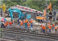  ?? (Adnan Abidi/Reuters) ?? HEAVY MACHINERY is used to remove damaged coaches from the railway tracks at the site of the train accident in the Balasore district of the eastern state of Odisha yesterday.