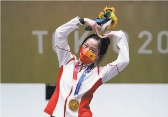  ?? Alex Brandon / Associated Press ?? Qian Yang of China narrowly beat out Russia’s Anastasiia Galashina to win the gold medal in the women’s 10meter air rifle event at the Asaka Shooting Range in Tokyo.
