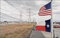  ?? Justin Sullivan / Getty Images ?? The American and Texas flags fly in front of high voltage transmissi­on towers in Houston.