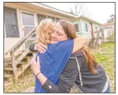  ??  ?? Sarah Kelly (right) is embraced by Sue Howland with the Quick Response Team after Howland presented her with a coin marking Kelly’s one-year anniversar­y in recovery outside her home in Guyandotte, W.Va.