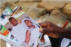  ??  ?? MONROVIA: James Harris, the husband of Salome Karwah, looks at pictures of his wedding day in his home on March 2, 2017. —AFP