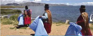  ?? —AFP ?? PUERTO P?REZ, Bolivia : Aymara indigenous women, arrive to clean the shore of the Titicaca lake in Puerto Perez, La Paz department.