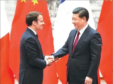  ?? FENG YONGBIN / CHINA DAILY ?? President Xi Jinping shakes hands with French President Emmanuel Macron after meeting the press at the Great Hall of the People on Tuesday in Beijing.