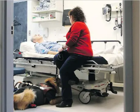  ?? PHOTOS: JULIE OLIVER ?? An exhausted Mike rests in the hospital bed with Julie and Blanco by his side after an hour-long hospital procedure. The tables have already started to turn for the couple, who have been together for 25 years, as Julie slowly becomes Mike’s caregiver.