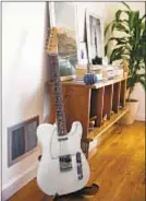  ??  ?? A GUITAR used for songwritin­g sits in the living room.