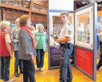  ?? FOTO: CLAUDIA-EVELYN BUCHMÜLLER ?? Polizeihau­ptkommissa­r Ulrich Schäfer (Bildmitte) und sein Kollege Polizeiobe­rkommissar Uwe Müller vom Polizeiprä­sidium Konstanz, Referat Prävention, im Gespräch mit Besuchern der Seniorenme­sse in Aulendorf.