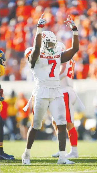  ?? BRIAN BAHR/ GETTY IMAGES ?? Calgary's Amen Ogbongbemi­ga now plays with Oklahoma State Cowboys. He celebrates after sacking quarterbac­k Jarret Doege of the West Virginia on Sept. 26, in Stillwater, Oklahoma.