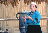  ??  ?? A woman wears traditiona­l Han dress at Tunpu in Anshun. The area still preserves traditions and cultures dating back to 600 years ago such as ancestor worship.