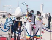  ?? SEBASTIAN SCHEINER/AP ?? Ethiopian immigrants wave Israeli flags as they arrive last year at Ben Gurion Airport near Tel Aviv.