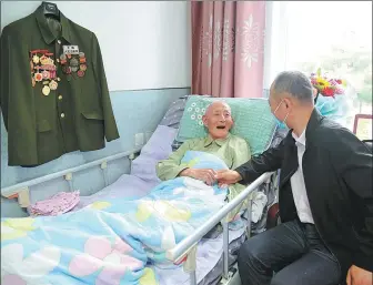  ?? XINHUA ?? Sun Jingkun talks with the head of his nursing home in Dandong, Liaoning province, on July 10.