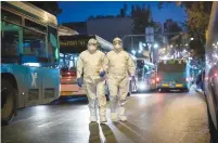  ?? (Yonatan Sindel/Flash90) ?? MDA PARAMEDICS arrive to test a patient with symptoms of the coronaviru­s in Jerusalem yesterday.