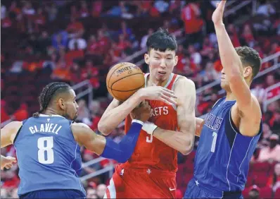  ?? GEORGE BRIDGES / AP ?? Houston Rockets’ Chinese player Zhou Qi loses possession after being crowded out by Dallas Mavericks duo Gian Clavell and Dennis Smith Jr. during an NBA game on Oct 21 in Houston.