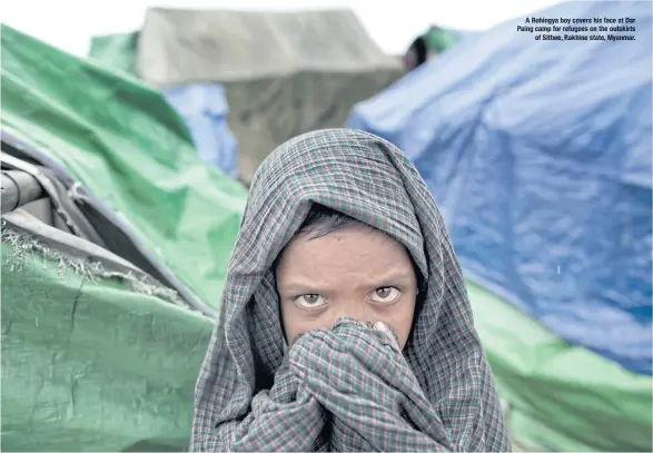  ??  ?? A Rohingya boy covers his face at Dar Paing camp for refugees on the outskirts of Sittwe, Rakhine state, Myanmar.