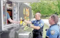  ?? Keith Bryant/The Weekly Vista ?? Andrew Hull (left) hands an ice cream cone to Bentonvill­e police Officer Danny Henry while Cpl. John Loncarevic stands by.