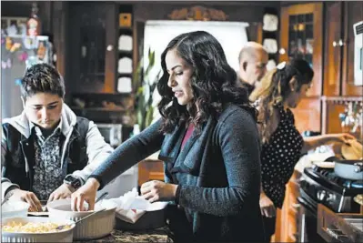  ?? BRIAN CASSELLA/CHICAGO TRIBUNE PHOTOS ?? Sabine Gonzalez, center, cooks with her sister Samantha and parents, Maria and Roberto, on Tuesday in their Glendale Heights home.