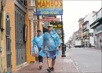  ?? David J. Phillip / Associated Press ?? Alan and Dot Richardson, from England, wear ponchos as they walk along Bourbon Street in the French Quarter in New Orleans on Friday, ahead of Tropical Storm Barry.
